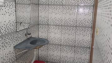A small bathroom with tiled walls, a sink, and a window.