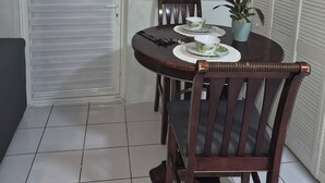 A dining area with a round table, chairs, and a potted plant. - 15 MINUTES WALK TO THE BEACH (Nassau)