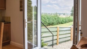 Ein Zimmer mit einer Schiebetür aus Glas, die zu einem Garten führt.