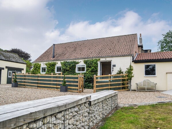 A building with a tiled roof, a wooden fence, and a stone wall. - The Sheep Shed - UK38437 (Bridlington)
