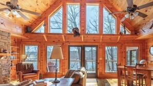 A log cabin interior with a dining area, seating, and a fireplace. - Expansive Lake Front Log Cabin/Easy Walk to Private! (Jacksboro)
