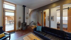Cozy living space with a fireplace, leather sofa, and dining table.