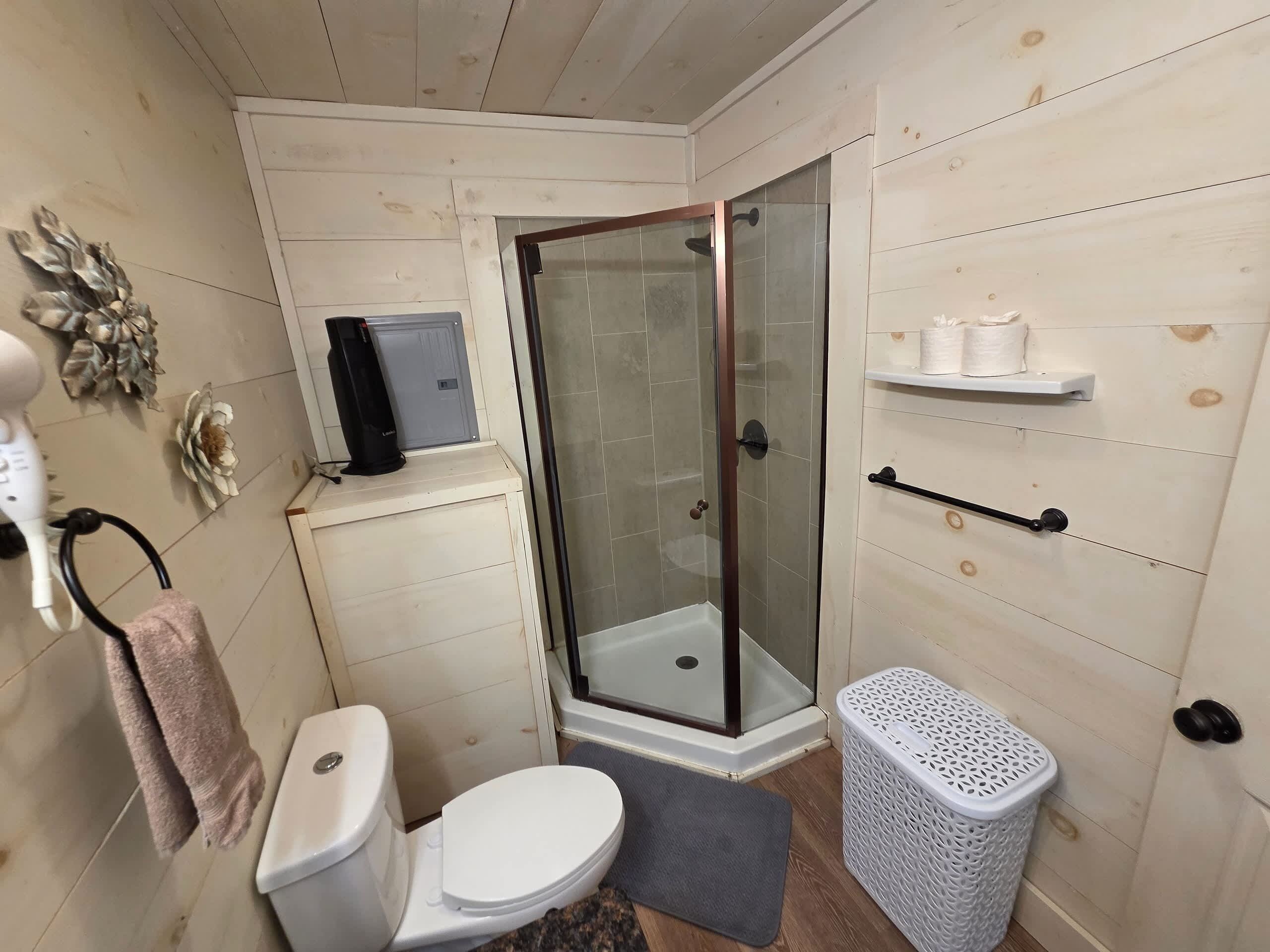 Een badkamer met toilet, douche en een handdoekhouder.