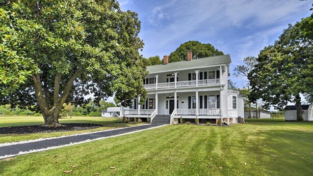 A large, two-story white house with a front porch and a well-maintained lawn. - Stunning historic home w/ large rooms. Close to attractions. Kid & pet friendly! (Sellers)