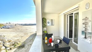 A balcony with a table set for two, overlooking a beach. - Le discret - Plage de Foncillon 4* (in French) (Royan)