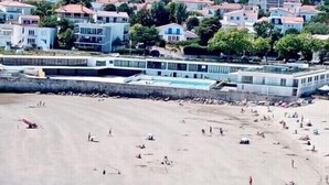 A beach with people sunbathing and swimming, and buildings in the background. - Le discret - Plage de Foncillon 4* (in French) (Royan)