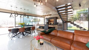 Un espacio de estar moderno con comedor, sofá, mesa de centro y cocina con isla integrada.
