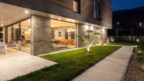 Una casa moderna con un patio amplio, un interior luminoso y un jardín cuidado.