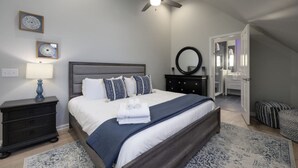 A bedroom with a bed, a nightstand, a dresser, a mirror, and a ceiling fan. - The Nashville Oasis | Ultimate Outdoor Escape (Nashville)