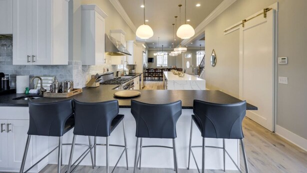 A modern kitchen with a central island, bar stools, and pendant lighting. - The Nashville Oasis | Ultimate Outdoor Escape (Nashville)