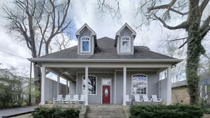 A two-story house with a porch, a red door, and a small tower-like structure on the roof. - The Nashville Oasis | Ultimate Outdoor Escape (Nashville)