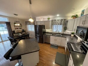 Una cocina moderna con una isla central, electrodomésticos integrados y un comedor con mesa y sillas.