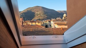 A view from a window overlooking a cityscape with a mountain in the background. - CadeFe Loft loft in historic downtown (La Spezia)