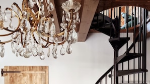 A modern interior with a wooden door, a black spiral staircase, and a chandelier. - CadeFe Loft loft in historic downtown (La Spezia)