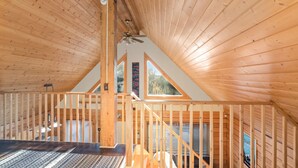 A wooden interior with a sloped ceiling, a staircase, and large windows. - Dreamy 2 Bed Cabin #2 - Alaska Kenai Getaway (Sterling)