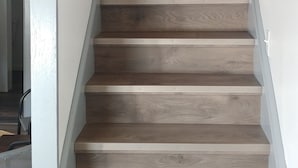 A wooden staircase with white railings and a ceiling light. - Binnekill Views- Cozy Apt over looking the Binnekill stream (Margaretville)