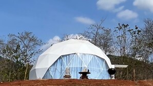 A dome-shaped structure with a white exterior and blue interior, surrounded by trees and a clear sky. - Dome tent in beautiful countryside, 20 minutes from the beach (Santa Marta de Hojancha)