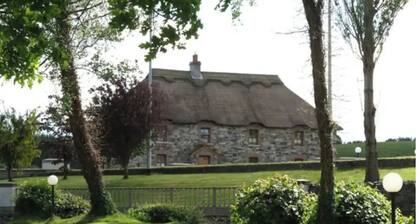 Idyllic rural retreat,stone walled thatched roof building set among the drumlins