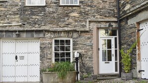 A stone building with multiple windows and doors, a sign reading 'Methera 4', and a no parking sign.