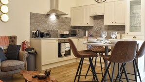 A modern kitchen with a dining area, a sofa, and a coffee table.