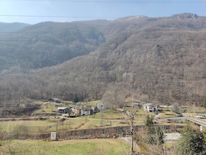 A rural landscape with houses, a stone wall, and a bridge. - Vacation home Il Corbetto in Locana at the foot of the Gran Paradiso National Park (locana)