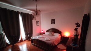 Une chambre à coucher avec un lit en bois, une table de chevet et une lampe, ainsi qu’un radiateur.