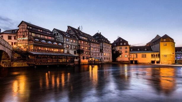 A historic building with a river in front, featuring traditional architecture and a bridge. - Gîte Le Chut - Jacuzzi & Swimming pool - 22km Strasbourg (Rangen)