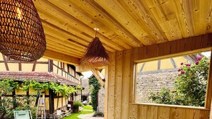 A hot tub with water, wooden ceiling, and a view of a garden. - Gîte Le Chut - Jacuzzi & Swimming pool - 22km Strasbourg (Rangen)