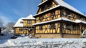 Ein traditionelles Fachwerkhäuschen mit einem steilen Dach, umgeben von Schnee.