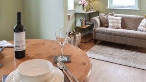A dining table with a bottle of wine, a glass, and a bowl set for two. - The Hen House - UK38436 (Bridlington)