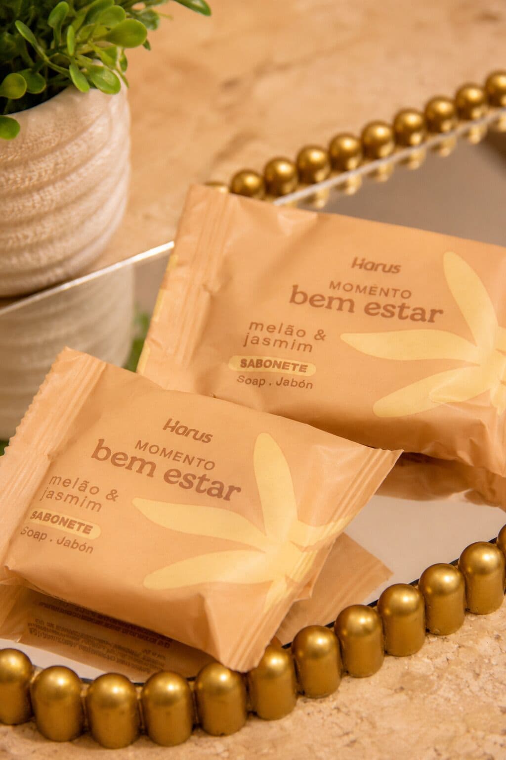 Two brown paper bags with the text 'Harus MOMENTO bem estar' and 'melão & jasmin SOAP. Jabón'.