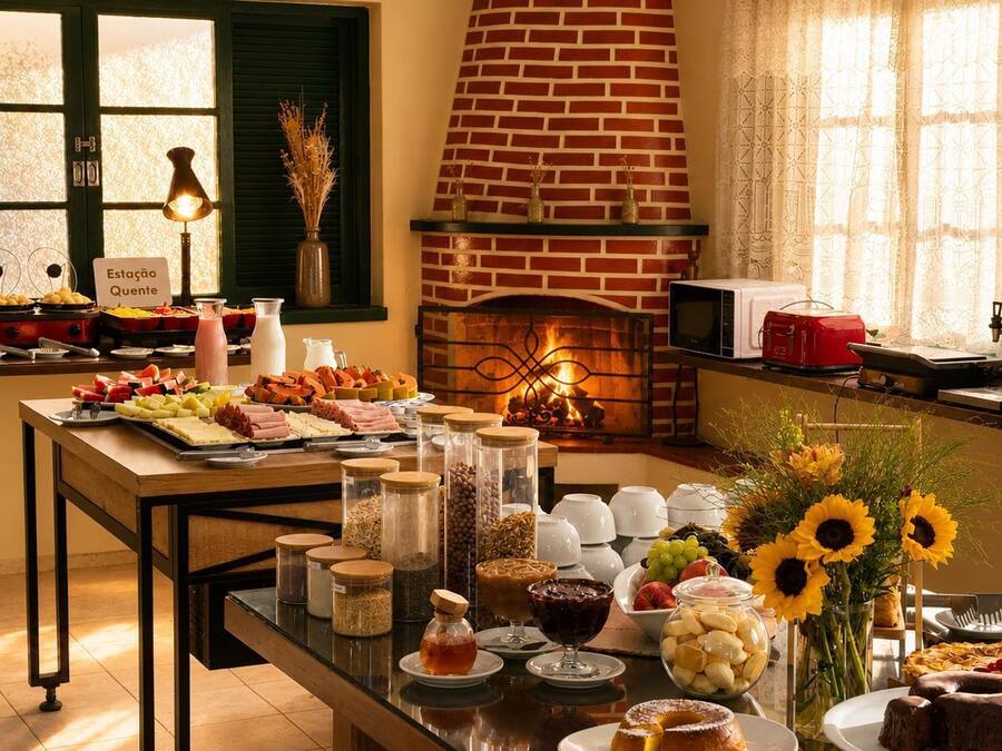 Un bufé de desayuno con diversas opciones de comida y una chimenea de ladrillo al fondo.