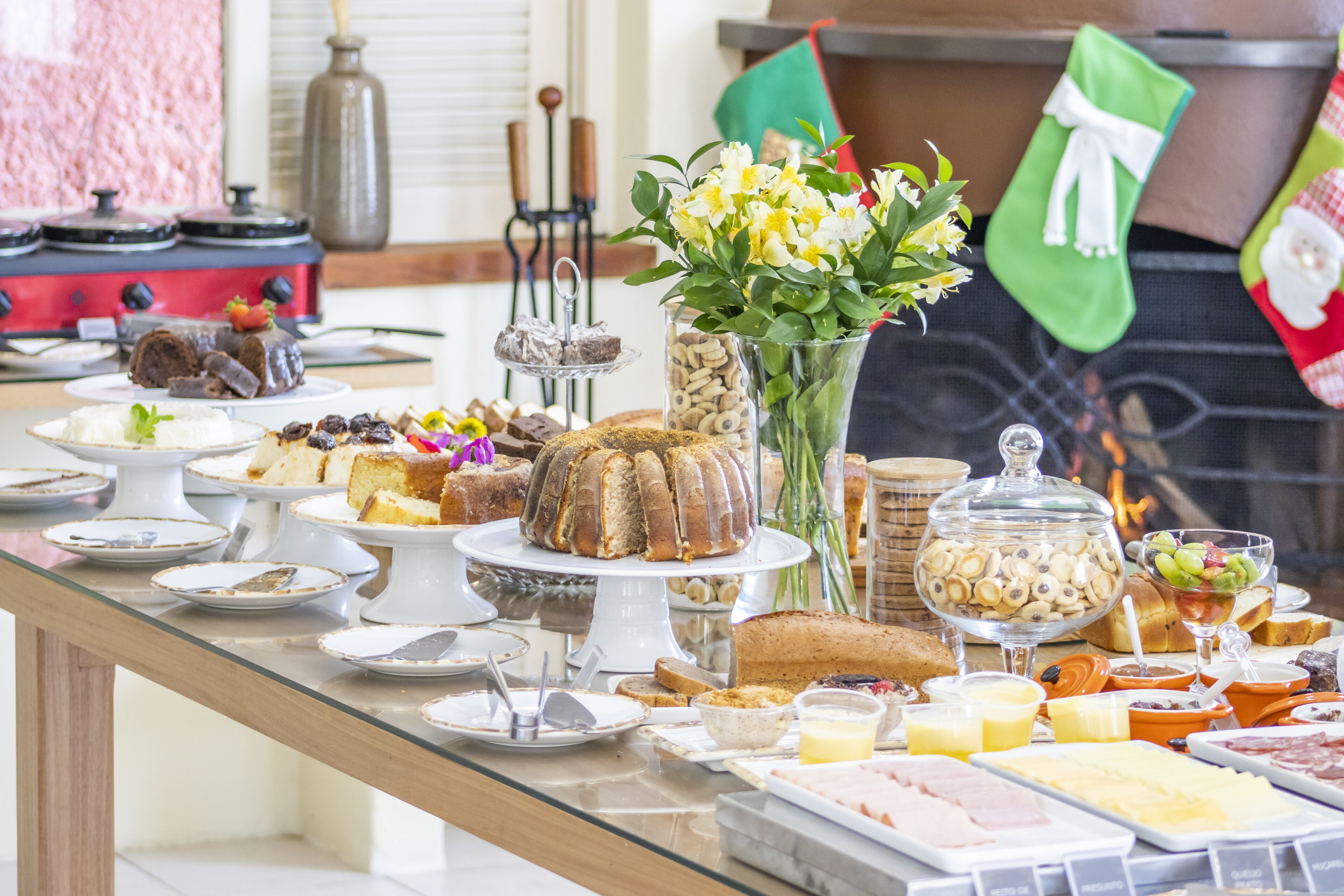 A buffet table with various food items and a vase of flowers.