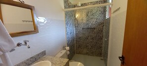 A bathroom with a sink, toilet, and shower area. - Pousada Três Marias Ilhabela (Ilhabela)