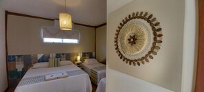 A hotel room with two beds, a window, a wall-mounted lamp, and a decorative wall piece. - Pousada Três Marias Ilhabela (Ilhabela)