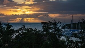 A marina with boats docked, surrounded by trees and a sunset in the background. - Red Sunset Beach Club (Cabo Rojo)