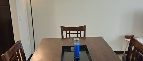 A dining table with chairs, a tray with a blue object, and a floor lamp.