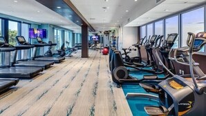 A gym with treadmills, elliptical machines, and exercise balls.