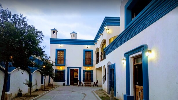 A courtyard with a central building featuring a staircase, a small seating area, and a tree. - ANTIQUE Garcia (Garcia)