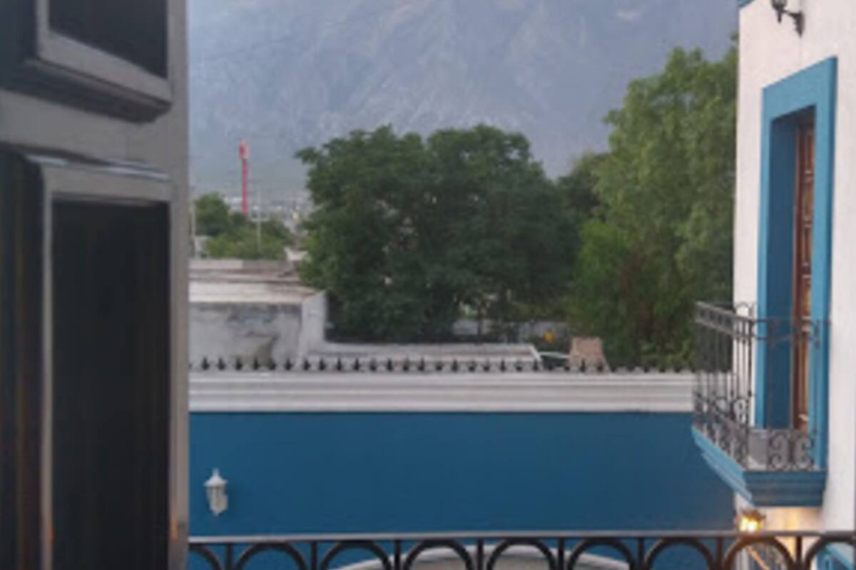A balcony with a view of mountains and trees.