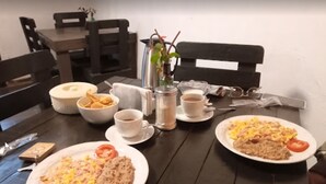A dining table with plates of food, cups, and a pitcher. - ANTIQUE Garcia (Garcia)