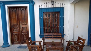 A building with a wooden door and window, blue trim, and a wrought iron gate. - ANTIQUE Garcia (Garcia)