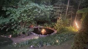 A pond with a water feature, surrounded by greenery and a stone border. - Quaint Pond Suite for 2 • Clean • Cozy • Private • 25 miles to Traverse City (Fife Lake)
