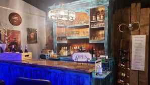 A bar area with a sign indicating it's open, shelves with bottles, and a menu on the wall listing wine options. - HOCHATOWN Charming Hotel Garden suite. (Broken Bow)