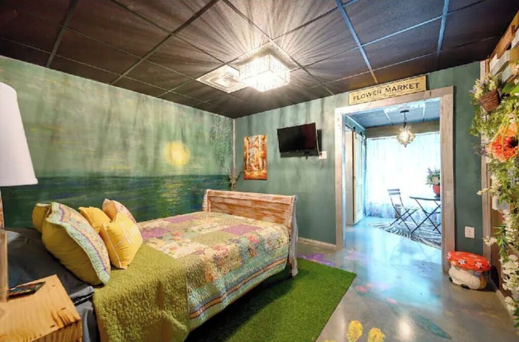 A bedroom with a bed, a TV, and a sign for the flower market.