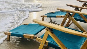 Beach chairs on the sand near the water.