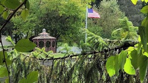 Een prieel met een vlaggenmast en een Amerikaanse vlag in een park.