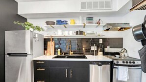 Une cuisine moderne équipée d’un réfrigérateur en acier inoxydable, d’un lave-vaisselle, d’une cuisinière et d’un évier.