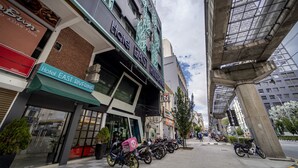Un hotel con un cartel que dice "Hotel East Riverine" y una tienda 7-Eleven cerca.