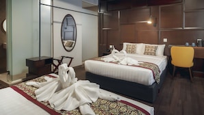 Una habitación de hotel con dos camas, un escritorio, una silla y un espejo.
